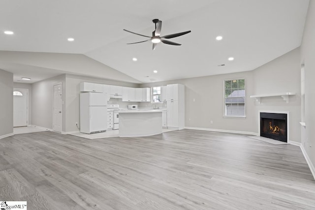 338 E Celestial Dr, Greer, SC 29651 - unfurnished living room featuring vaulted ceiling, ceiling fan, a fireplace with flush hearth, plenty of natural light, and light wood-style floors