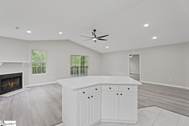 338 E Celestial Dr, Greer, SC 29651 - kitchen with open floor plan, a ceiling fan, light wood-style flooring, light countertops, and a fireplace with flush hearth