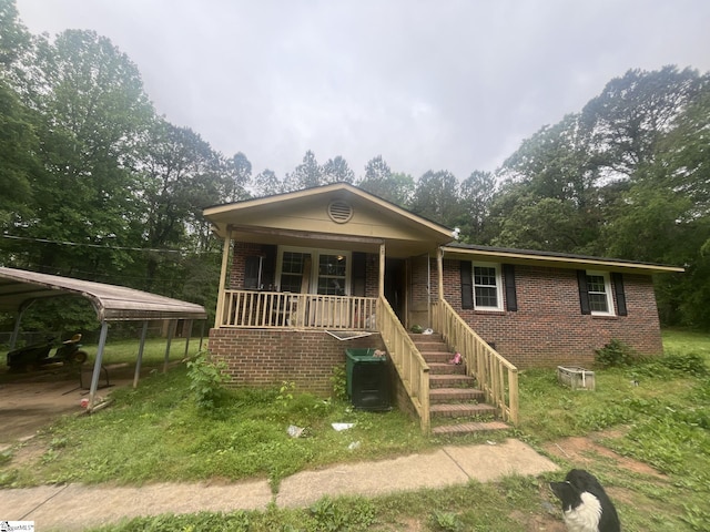 208 Baldwin Circle Ext, Clinton, SC 29325 - view of front of house featuring covered porch, brick siding, stairs, a detached carport, and central AC