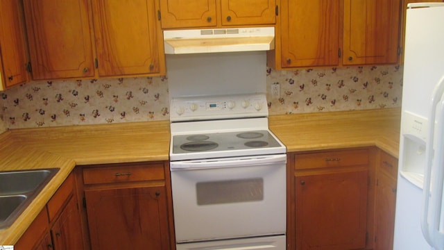 320 N Adair St, Clinton, SC 29325 - kitchen featuring white appliances, under cabinet range hood, light countertops, brown cabinets, and a sink