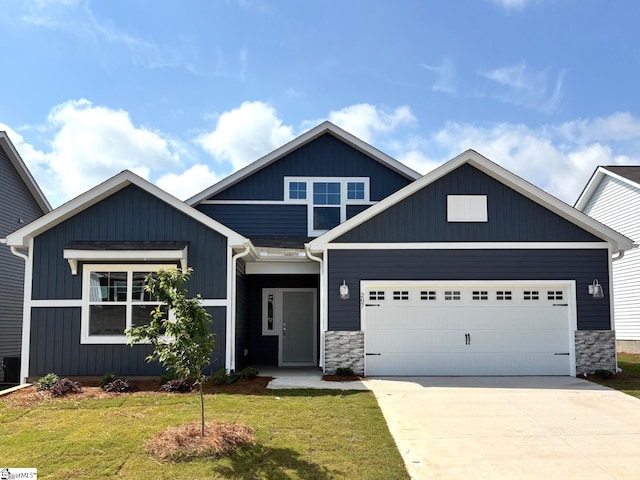 207 Fenner Pl, Greenville, SC 29607 - craftsman house featuring a garage, a front lawn, concrete driveway, and stone siding