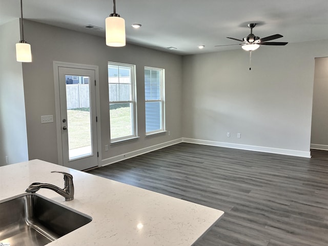 207 Fenner Pl, Greenville, SC 29607 - kitchen with a sink, dark wood-style floors, a ceiling fan, baseboards, and hanging light fixtures