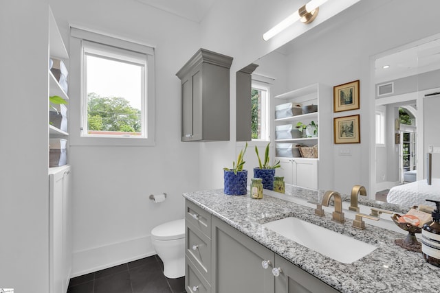 bathroom featuring tile patterned flooring, toilet, and vanity