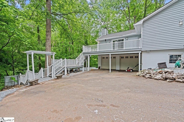150 Orchard Dr, Inman, SC 29349 - back of house featuring stairs, a chimney, a garage, driveway, and view of scattered trees
