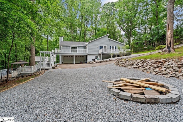 150 Orchard Dr, Inman, SC 29349 - view of front of house featuring a chimney, a garage, view of scattered trees, gravel driveway, and stairs