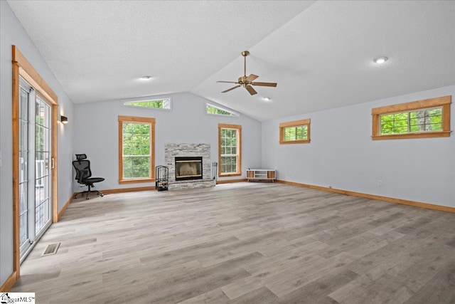 150 Orchard Dr, Inman, SC 29349 - unfurnished living room featuring a stone fireplace, wood finished floors, ceiling fan, lofted ceiling, and healthy amount of natural light