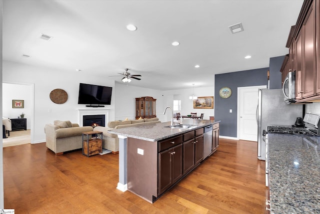 205 Hartwood Lake Ln, Greer, SC 29650 - kitchen with a sink, a ceiling fan, stainless steel appliances, light wood finished floors, and a kitchen island with sink