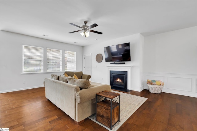 205 Hartwood Lake Ln, Greer, SC 29650 - living area with a ceiling fan, a fireplace with flush hearth, dark wood finished floors, wainscoting, and baseboards