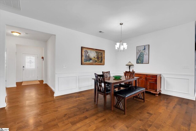205 Hartwood Lake Ln, Greer, SC 29650 - dining area with a chandelier, dark wood-type flooring, a decorative wall, and wainscoting