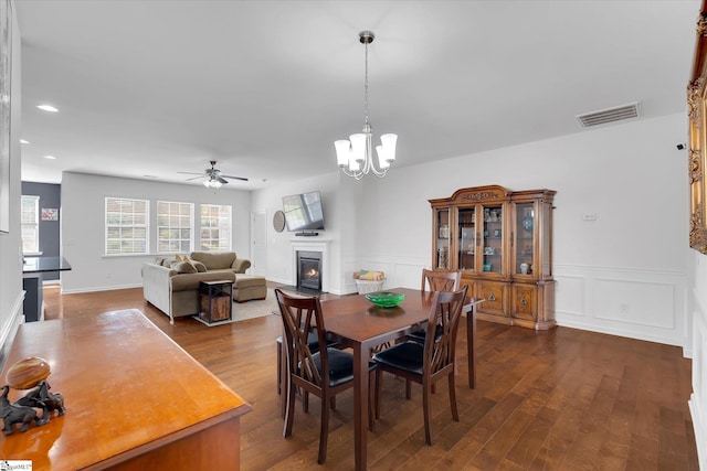 205 Hartwood Lake Ln, Greer, SC 29650 - dining area featuring ceiling fan, dark wood-type flooring, a glass covered fireplace, wainscoting, and a chandelier