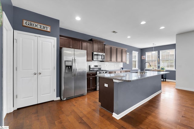 205 Hartwood Lake Ln, Greer, SC 29650 - kitchen with stainless steel appliances, dark wood-style flooring, a center island with sink, dark brown cabinets, and light stone countertops