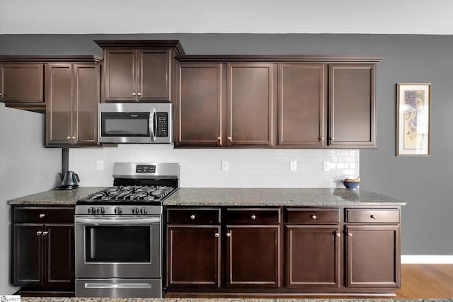 205 Hartwood Lake Ln, Greer, SC 29650 - kitchen with stainless steel appliances, backsplash, stone counters, and dark brown cabinetry