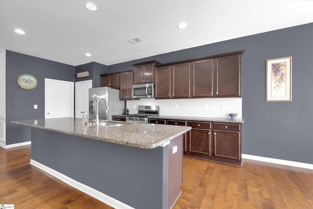 205 Hartwood Lake Ln, Greer, SC 29650 - kitchen featuring appliances with stainless steel finishes, a sink, an island with sink, baseboards, and dark wood finished floors