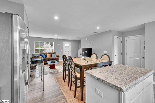 145 Queens Mill Ct, Pendleton, SC 29670 - kitchen with stainless steel fridge, light wood-style flooring, open floor plan, a kitchen island, and light countertops