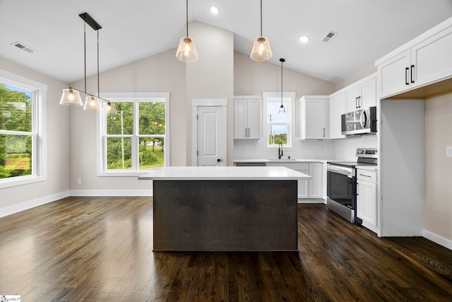 1047 Ansel School Rd, Greer, SC 29651 - kitchen with appliances with stainless steel finishes, light countertops, white cabinetry, a kitchen island, and high vaulted ceiling