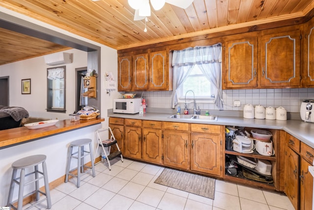 402 Terrapin Rd, Union, SC 29379 - kitchen with a sink, white microwave, wooden ceiling, ornamental molding, and brown cabinetry