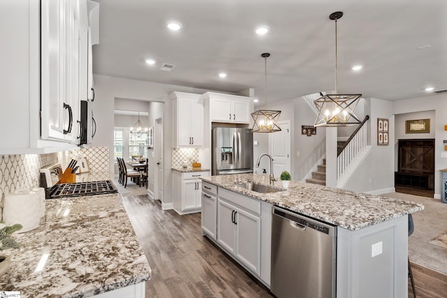 907 Whitemarsh Ave, Simpsonville, SC 29680 - kitchen featuring appliances with stainless steel finishes, a sink, a chandelier, decorative backsplash, and light stone counters