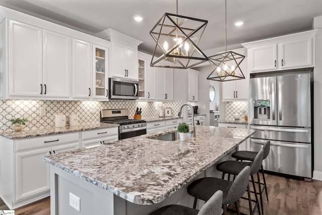 907 Whitemarsh Ave, Simpsonville, SC 29680 - kitchen with appliances with stainless steel finishes, a sink, white cabinetry, dark wood-style flooring, and an island with sink