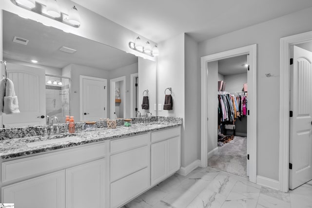 907 Whitemarsh Ave, Simpsonville, SC 29680 - bathroom featuring marble finish floors, a stall shower, baseboards, double vanity, and a walk in closet
