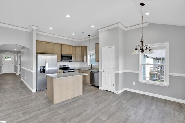 kitchen featuring stainless steel appliances, a sink, arched walkways, a kitchen island, and a chandelier