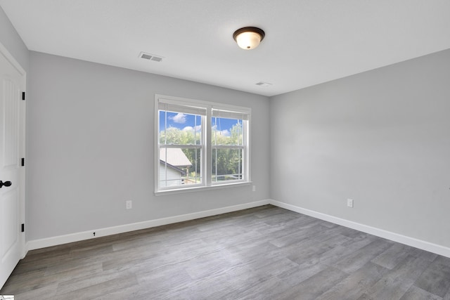 spare room featuring wood finished floors and baseboards