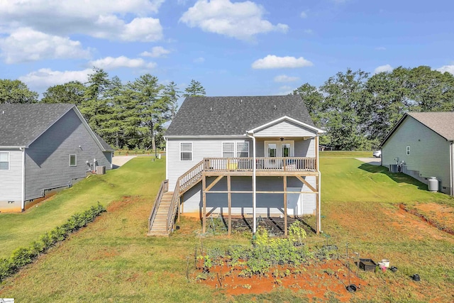 back of house featuring stairs, a wooden deck, a yard, and roof with shingles