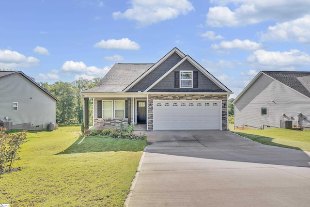 view of front of house with driveway, a front yard, stone siding, and central AC unit