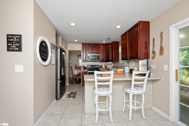 113 Faulkner Cir, Greer, SC 29651 - kitchen featuring stainless steel appliances, a peninsula, light countertops, light tile patterned floors, and baseboards
