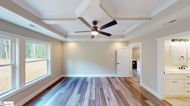unfurnished bedroom featuring light wood-style floors, baseboards, and connected bathroom