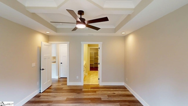 unfurnished bedroom featuring a tray ceiling, recessed lighting, light wood-type flooring, baseboards, and ceiling fan