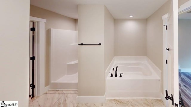 bathroom featuring a bath, marble finish flooring, baseboards, and recessed lighting