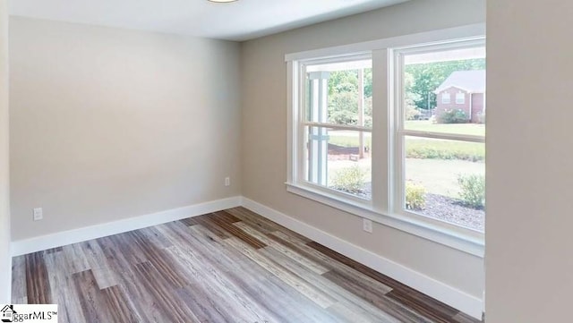 unfurnished room featuring baseboards and wood finished floors