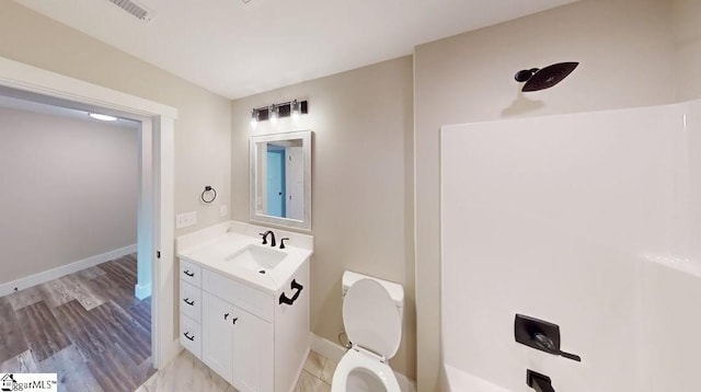 bathroom with vanity, baseboards, toilet, and wood finished floors