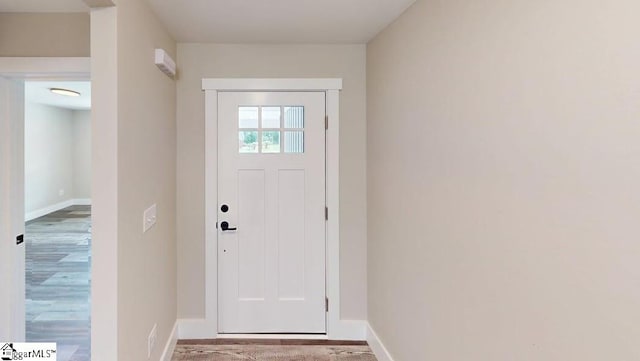 entryway with baseboards and wood finished floors