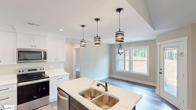kitchen with stainless steel appliances, a sink, hanging light fixtures, light wood finished floors, and recessed lighting