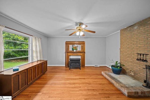 228 Styles Rd, Taylors, SC 29687 - unfurnished living room featuring brick wall, ceiling fan, light wood finished floors, a fireplace, and baseboards