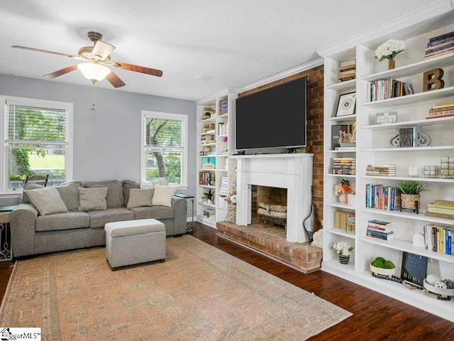 living room with a fireplace, wood finished floors, ceiling fan, and a textured ceiling
