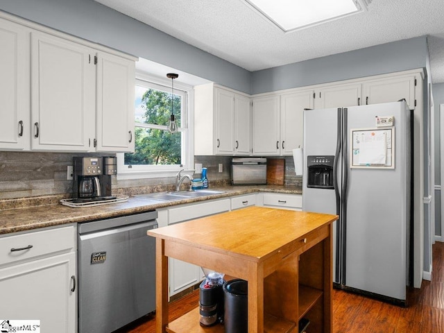 kitchen with stainless steel appliances, a sink, white cabinetry, and a textured ceiling
