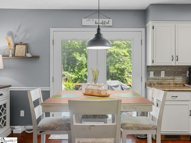 dining space with dark wood-style flooring