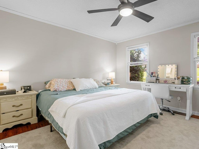 bedroom featuring ornamental molding, a ceiling fan, baseboards, and light carpet