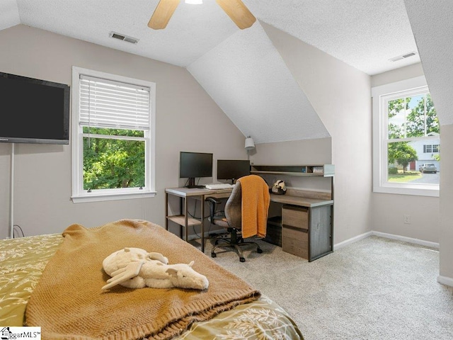 carpeted bedroom with lofted ceiling, a textured ceiling, a desk, a ceiling fan, and baseboards
