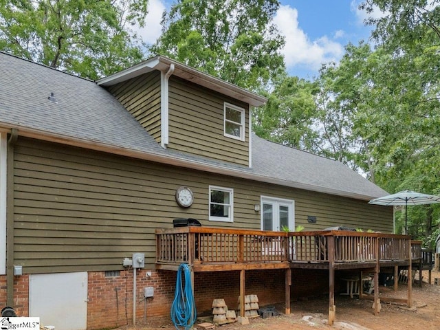 rear view of property with a deck, roof with shingles, and french doors