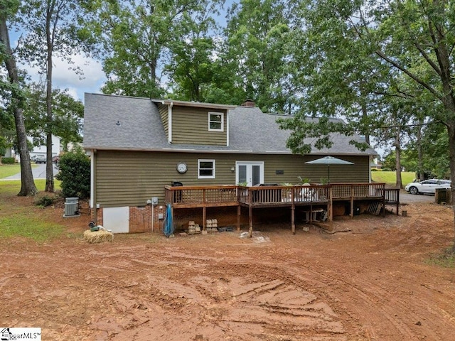 rear view of house featuring a wooden deck, french doors, a chimney, and roof with shingles