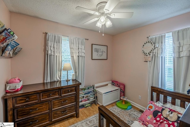 217 Ponder Rd, Greer, SC 29651 - bedroom featuring multiple windows, light wood-type flooring, a textured ceiling, and a ceiling fan
