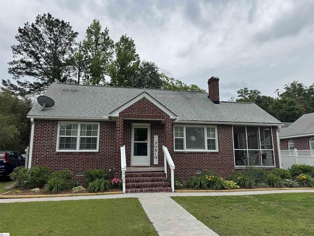 422 E Savannah St, Calhoun Falls, SC 29628 - view of front of property with brick siding, a chimney, a sunroom, and a shingled roof