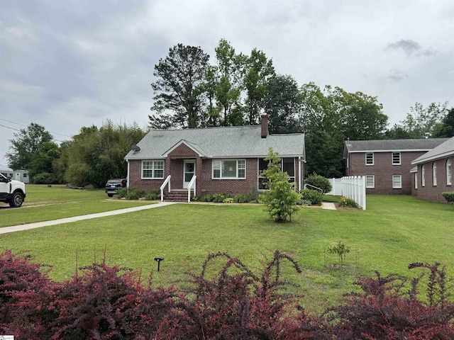 422 E Savannah St, Calhoun Falls, SC 29628 - view of front of house featuring a chimney, a front lawn, and brick siding