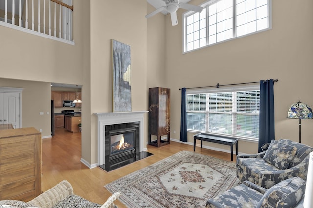 508 Inner Banks Rd, Boiling Springs, SC 29316 - living area featuring a high ceiling, ceiling fan, light wood-type flooring, a fireplace with flush hearth, and baseboards