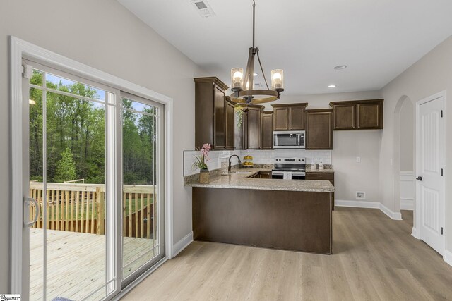 9 Amber Oaks Dr, Greer, SC 29651 - kitchen featuring appliances with stainless steel finishes, dark brown cabinets, backsplash, light wood-style flooring, and baseboards