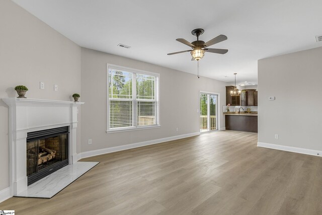 9 Amber Oaks Dr, Greer, SC 29651 - unfurnished living room with a high end fireplace, a ceiling fan, light wood-style flooring, and baseboards