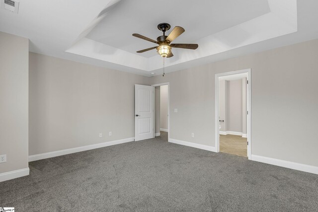 9 Amber Oaks Dr, Greer, SC 29651 - unfurnished bedroom featuring a tray ceiling, carpet flooring, baseboards, ceiling fan, and ensuite bath